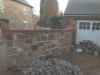 Pitched red sandstone copings on a garden wall