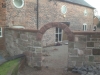Pitched red sandstone wall copings with a twice-weathered profile